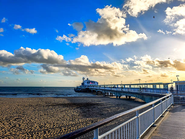 istock A pier is visible on the beach with a boat in the water 2208732027