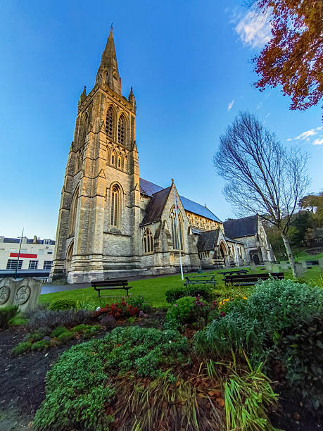 istock A large church with a steeple and a small courtyard with benches and a few trees 2208732132