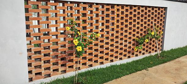 Exposed brick wall with yellow flowers on a sunny day