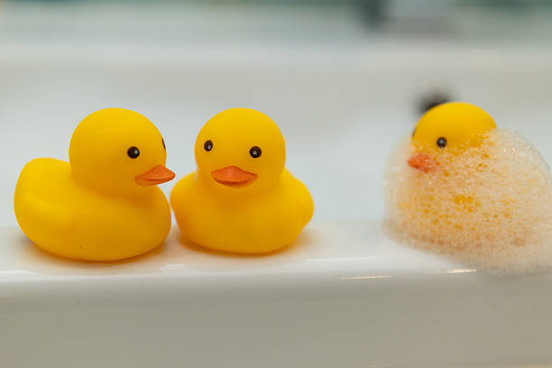 A group of playful rubber ducks is having fun amidst a bubbly and cheerful bathtub scene filled with joy