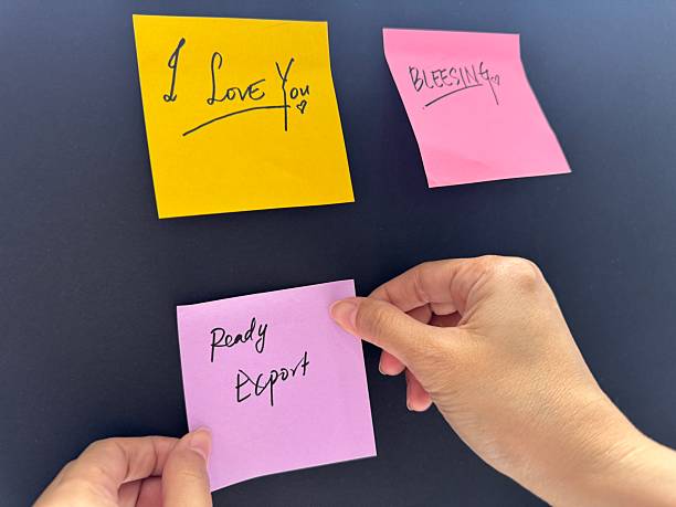 istock Close up an Woman's hand putting glues sticker or sticky notes on wall background 2208752150