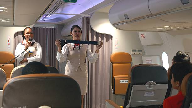 istock Asian stewardess safety explaining passengers how to use seat belt fastening in airplane 2208752455