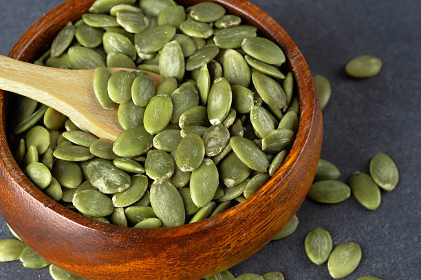 istock Delicious pumpkin seeds on black background 2208759983