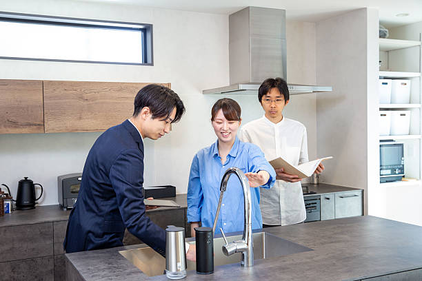 istock Housing sales: Japanese person explaining the kitchen in a model house 2208765701