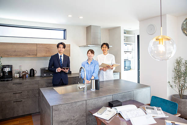 istock Housing sales: Japanese person explaining the kitchen in a model house 2208765728