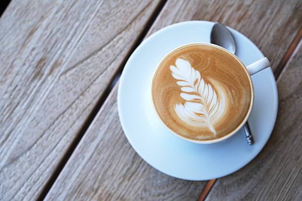 istock cup of coffee on wooden table, top down view 2208771974