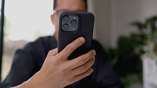 istock Asian man using voice assistant speaking through a cell phone while working on the laptop in the office. Ai assistant content. 2208776842