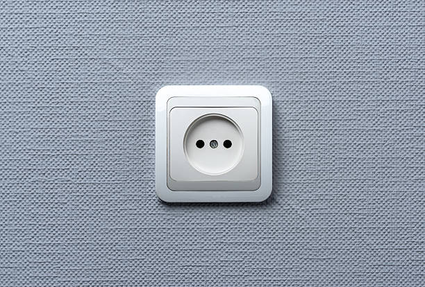istock A white European-style electrical wall socket mounted on a textured light gray wall. The photo is minimalistic, centered, and well-lit. 2208778813