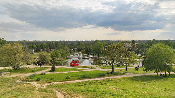 istock Big green park, pond and red bus 2208782074