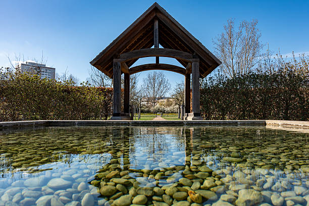 A beautiful pond with a stone walkway and a gazebo. The pond is surrounded by a stone walkway and a gazebo, creating a serene and picturesque setting. The water is calm and clear