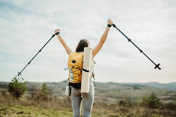 istock Young woman hike or trek and explore scenic forest with hiking sticks 2208793220
