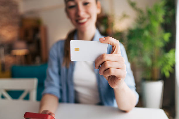 istock Young woman holding credit card and using nfc technology on smartphone 2208793690