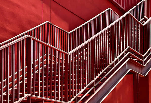 istock A set of stairs ascending a large red wall 2208798548