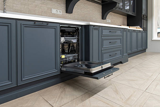 istock Integrated dishwasher with open door in blue kitchen cabinet 2208801105