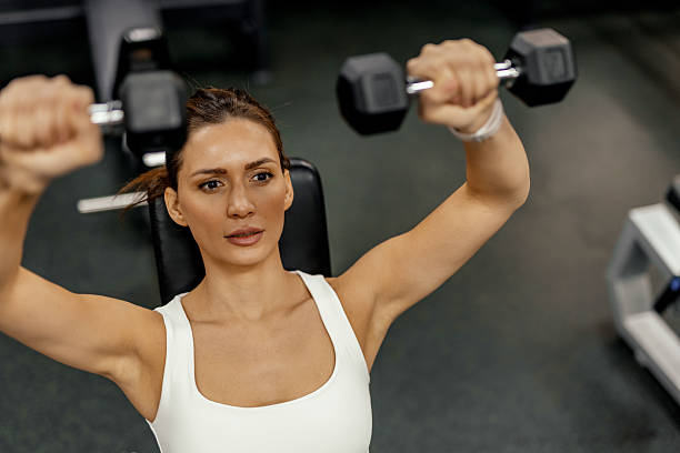 istock Empowered Fitness: Woman Building Strength with Dumbbells 2208803170