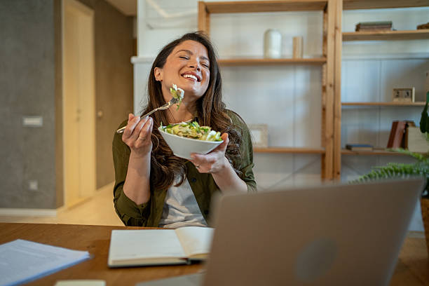 istock Happy freelancer eating a fresh salad while working from home 2208807140