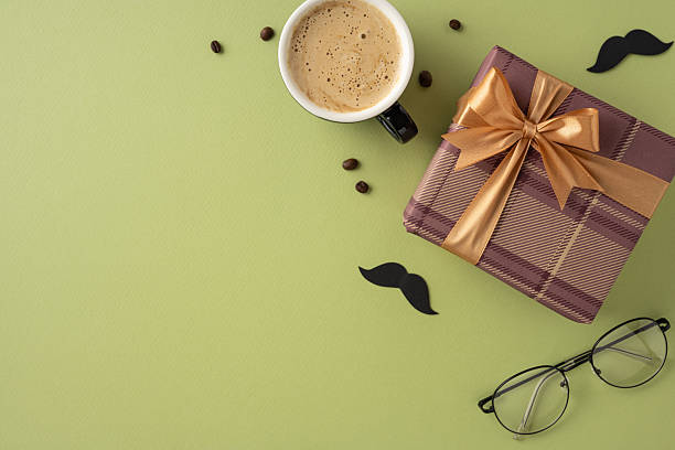 istock A stylish composition featuring a present decorated with a bow, a cup of coffee, eyeglasses, and decorative moustache over green surface. Ideal for celebratory occasions and masculine-themed concepts 2208807173
