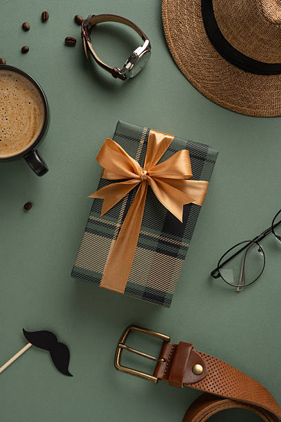 istock Gift box with ribbon, coffee, glasses, and accessories arranged on a vertical green background 2208807176