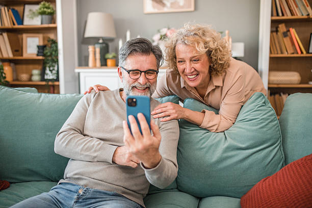 istock A cheerful man and a woman are having crazy fun using a smartphone at home 2208808631