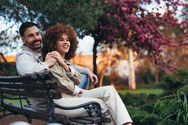 The East Asian couple is sitting and relaxing in the park.