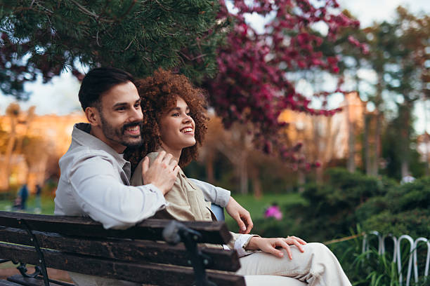 istock Young couple relaxing on a bench in a park during autumn 2208809940