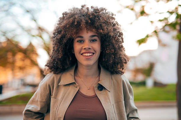 istock Young woman smiling and posing in the park 2208810133