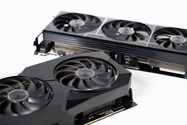 istock Two black graphics cards with cooling fans placed on white background, one with two coolers and another with three coolers for gaming PC 2208814527