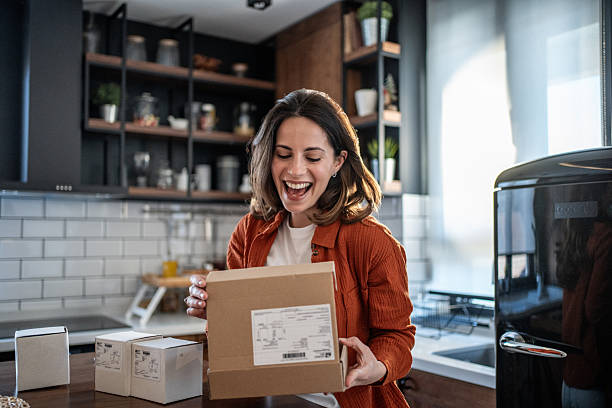 Excited woman opening a package in her modern kitchen