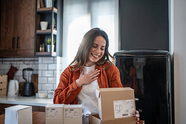 istock Happy woman unboxing packages in a modern kitchen 2208822851