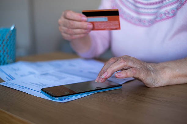 istock a woman's hand is paying with a card over the phone 2208826086