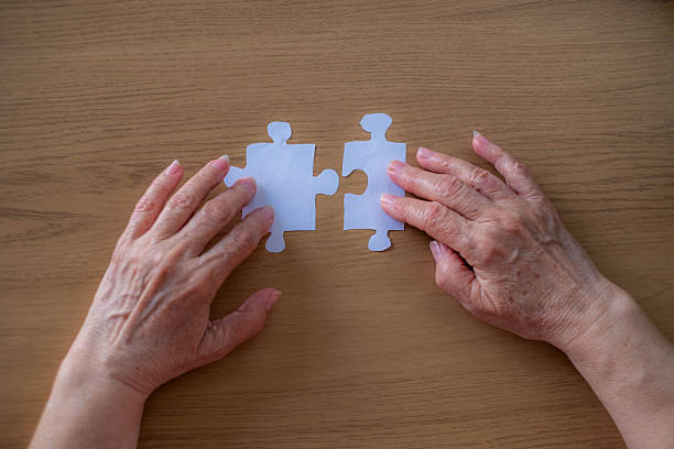 istock Grandma puts together paper puzzles. 2208826962