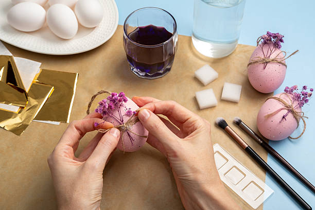 istock Happy Easter! Close-up of woman's hands painting an easter egg. Decorating Easter Eggs with Flower Sprigs. Step by step instructions. DIY concept. 2208827015