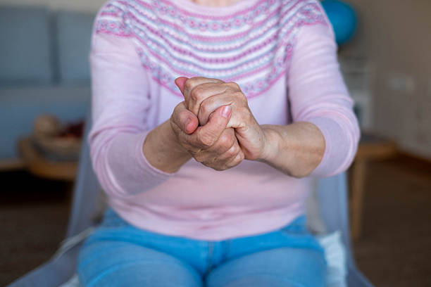 istock an elderly woman is rubbing hand cream on her hands 2208827130