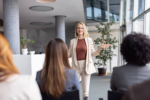 istock Confident Female Speaker Presenting to Enthusiastic Audience 2208827230