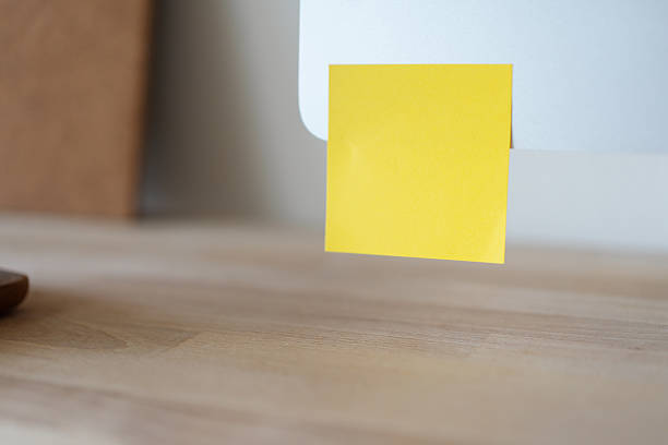 istock Empty yellow sticky note on a computer monitor, viewed from side. 2208827550