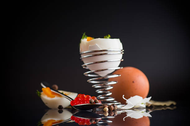 delicacy with red caviar and boiled egg for breakfast, isolated on black background.