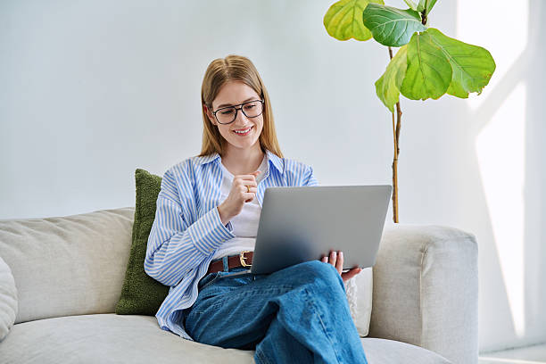 istock Young woman using laptop for video call, online chat conference sitting at home 2208831413