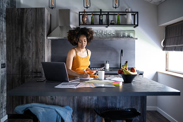istock Afro woman works diligently with documents in her kitchen 2208836265