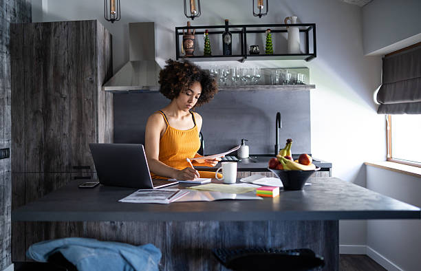 istock Afro woman works diligently with documents in her kitchen 2208836269