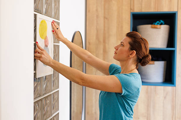 istock Woman Using Double-Sided Adhesive Tape for Framing Artwork/whiteboard at Home 2208836644