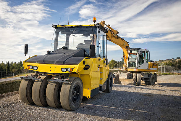 Bulldozer and roller compactor side by side on a building lot,