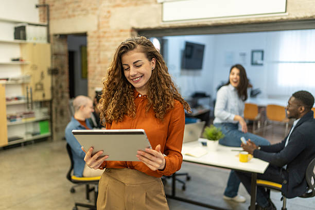 istock Confident young woman using digital tablet in creative office environment 2208840303