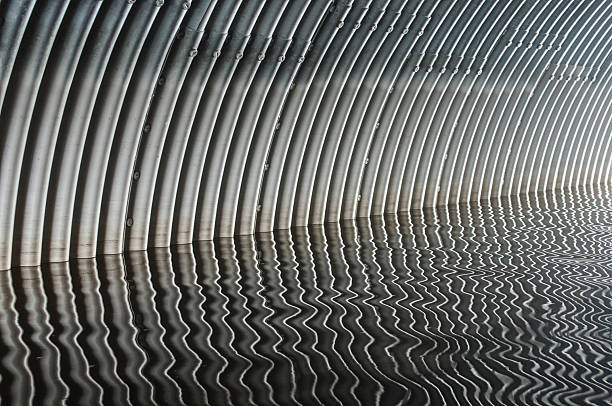 Culvert with flowing water creating reflective patterns in Sweden's natural landscape