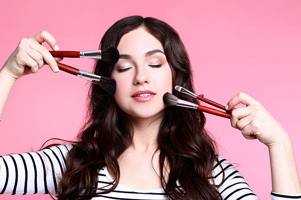 istock Beautiful woman with makeup brushes on pink background 2208841837