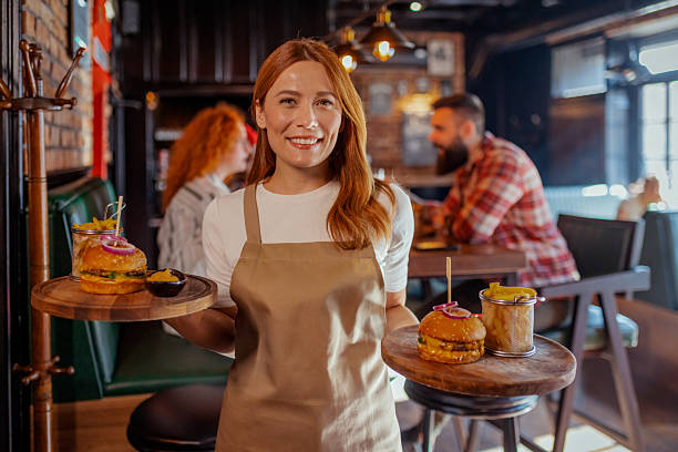 istock Warm Welcome: Attentive Waitress Serving Tasty Pub Food with Joy 2208843789
