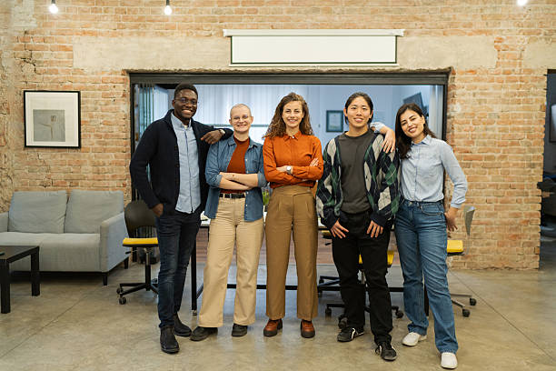 istock A diverse group of five young business people standing together in a modern co-working space, smiling confidently at the camera 2208845326
