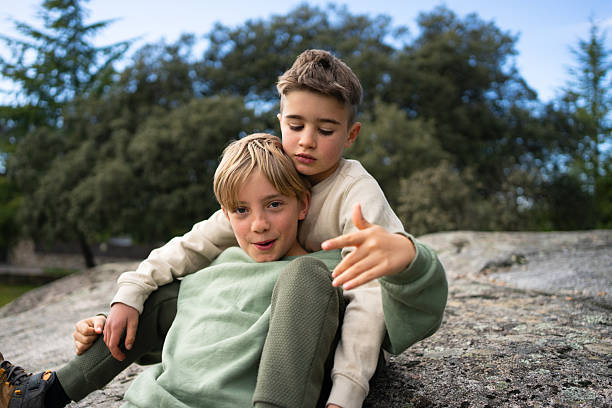 istock Two brothers posing together on a rock in nature 2208845507