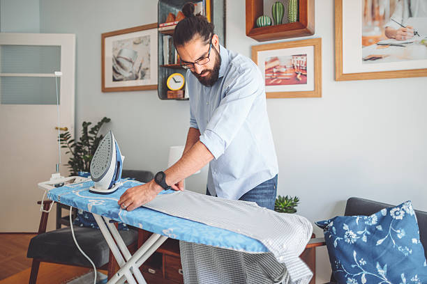 istock Young man ironing his shirt 2208846466