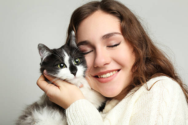 istock Beautiful young woman holding cat on grey background 2208848220