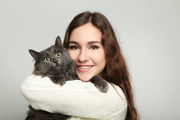 istock Beautiful young woman holding cat on grey background 2208848646